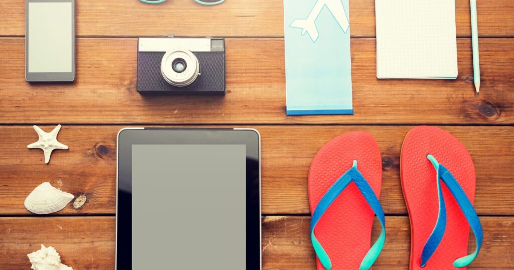 テーブルの上のタブレット、カメラ、サンダル