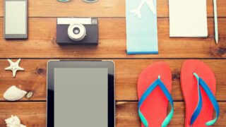 テーブルの上のタブレット、カメラ、サンダル