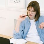 パソコンの前で悩む女性