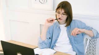 パソコンの前で悩む女性