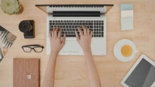 デスクの上でパソコンの作業を行う女性