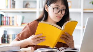 ホームぺージの作り方を本で学ぶ女性