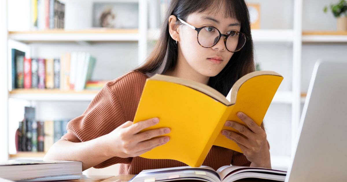 ホームぺージの作り方を本で学ぶ女性