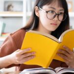 ホームぺージの作り方を本で学ぶ女性